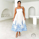 Attractive backless dress in white with blue floral embroidery on hem and straps