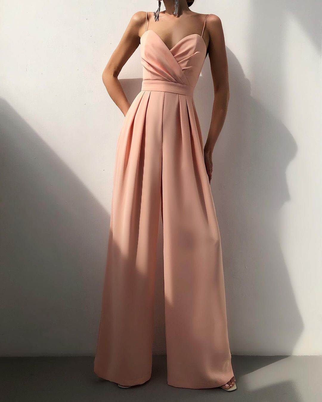 Blush pink strapless jumpsuit with pleated wide-leg pants, perfect for modern fashion ملابس