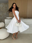 Woman in a white strapless dress showcasing the Gorgeous Midi Dress for modern fashion ملابس