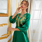 Langry emerald green satin gown with gold floral embroidery and bell sleeves