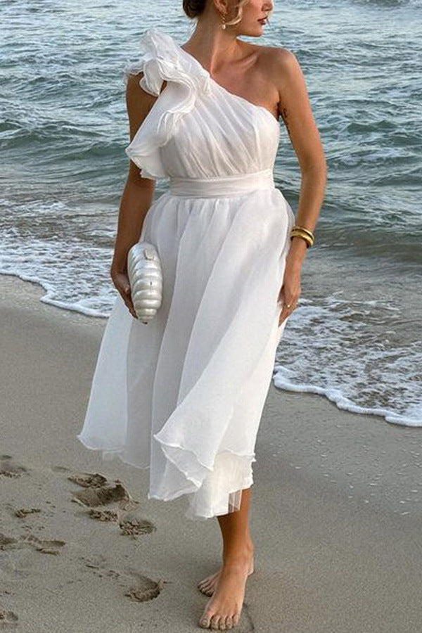 Flowing one-shoulder white dress with ruffles, perfect for fashion enthusiasts
