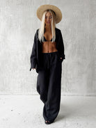Woman in black linen outfit and straw hat showcasing Langry fashion ملابس casual sets