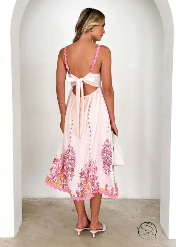 Attractive backless dress in white with pink floral details and tie-back design