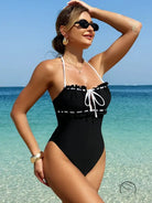 White black one-piece swimsuit with ruffle trim and lace-up neckline