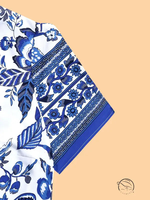 Blue white maxi dress with white fabric, blue floral leaf pattern, and banded sleeve border