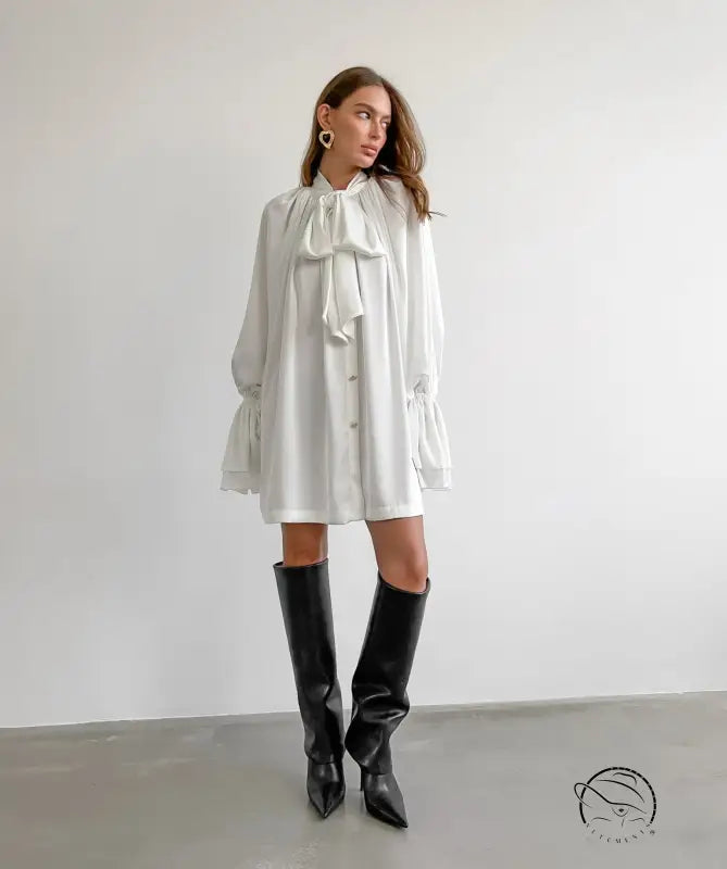Elegant satin dress with ruffled bow collar, long sleeves, and black boots