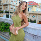 Woman in green langry fashion dress holding pearl clutch