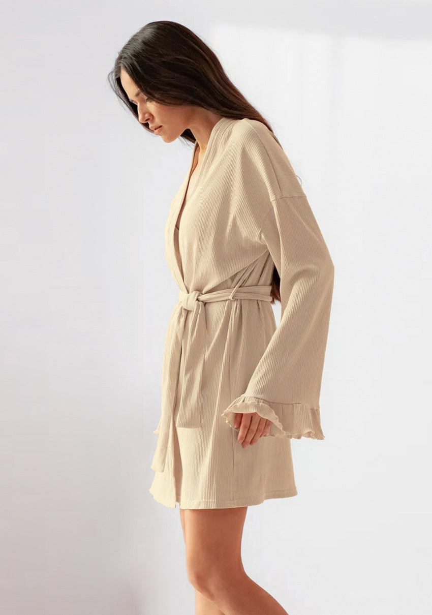 Woman wearing beige knitted casual cardigan nightgown with ruffled sleeves and tie waist