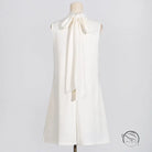 Sleeveless white dress with tie bow and floral design