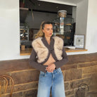 Brown fur-trimmed cropped cardigan coat with silver buttons and jeans