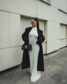 Stylish white ribbed maxi dress with long black coat and brown handbag