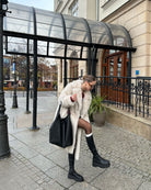 Warm faux fur coat with leather tote and knee-high boots
