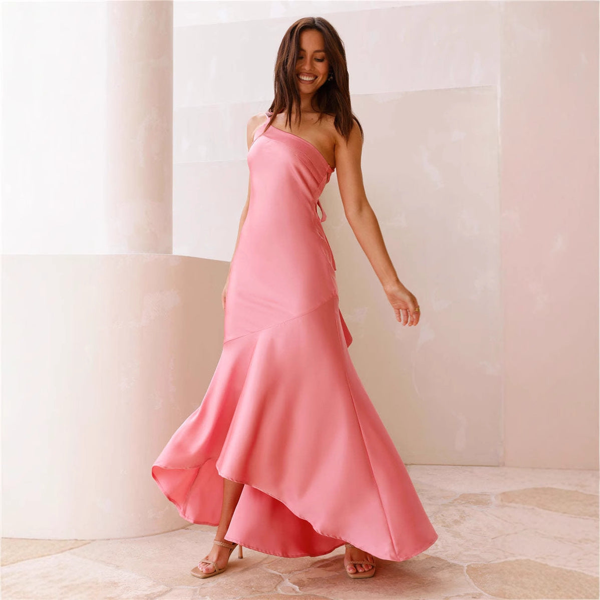 Pink one-shoulder fishtail dress with ruffled hem, showcasing elegant fashion design