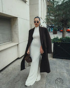 Elegant white maxi dress with black coat and sunglasses