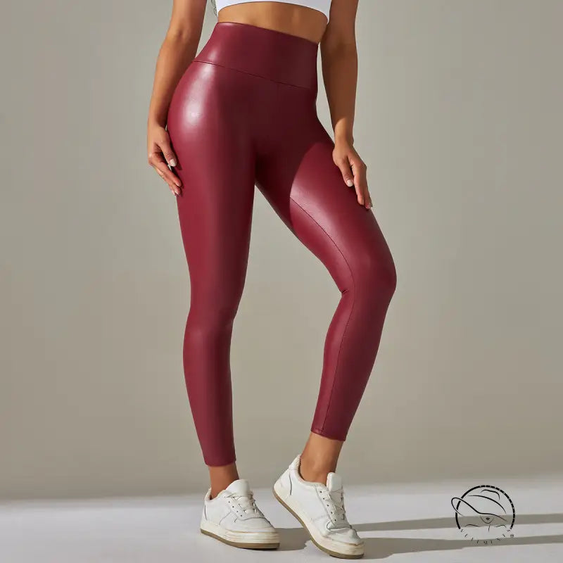 Burgundy high waist faux leather leggings with white sneakers and sports bra