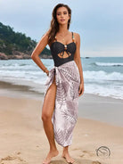 Light and elegant one piece swimsuit in black with pink leaf sarong