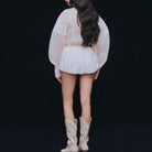 Fashionable loose langry top: white sheer blouse with ruffled hem and cream cowboy boots
