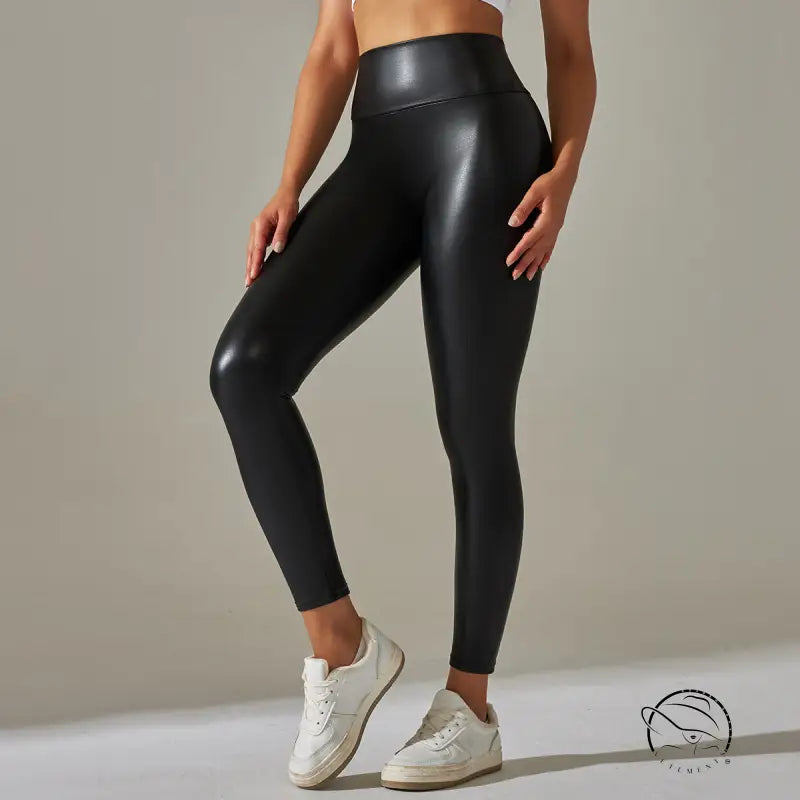 Black high waist faux leather leggings with glossy finish and white sneakers