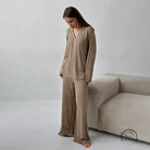 Woman modeling comfortable knitted pajamas in beige v-neck top and wide-leg pants