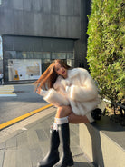 Short loose casual faux fur coat with black leather boots and silver buckle