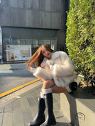 Short loose casual faux fur coat with black leather boots and silver buckle by Langry