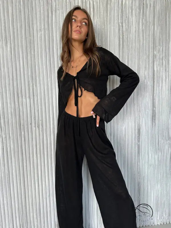 Woman in black casual loose pajamas: tie-front crop top and wide-leg pants
