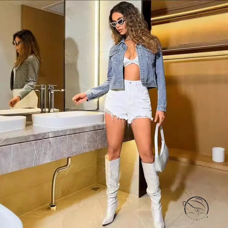 Woman in beaded loose Langry denim coat with white outfit and bag