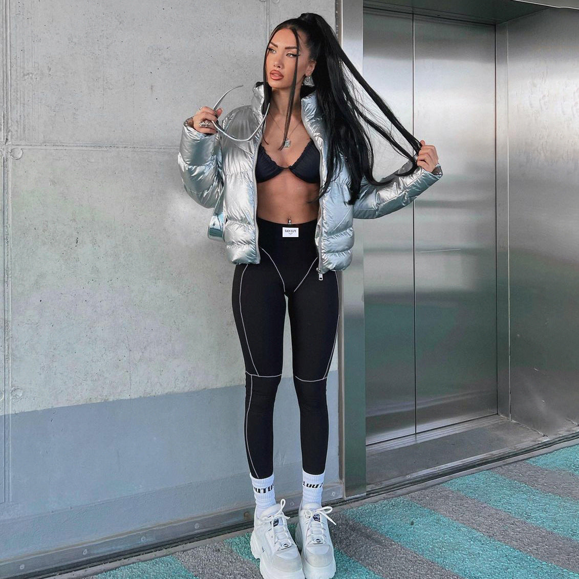 Woman wearing yoga primer skinny trousers in silver puffer jacket and black leggings