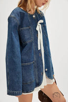 Woman modeling casual fashionable cowboy coat in denim with white ribbon detail