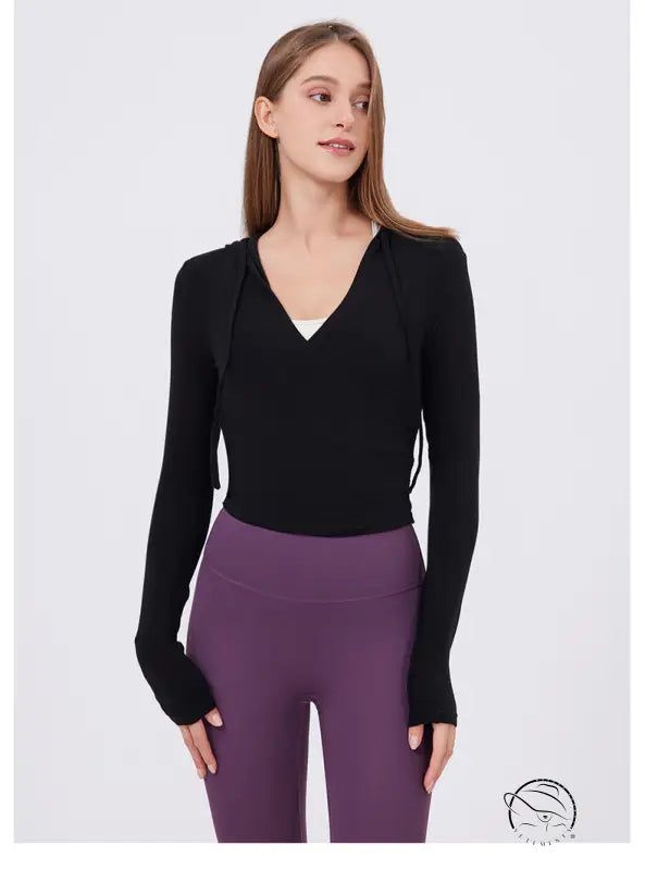 Slim fit slimming black V-neck hoodie with side ties over purple leggings