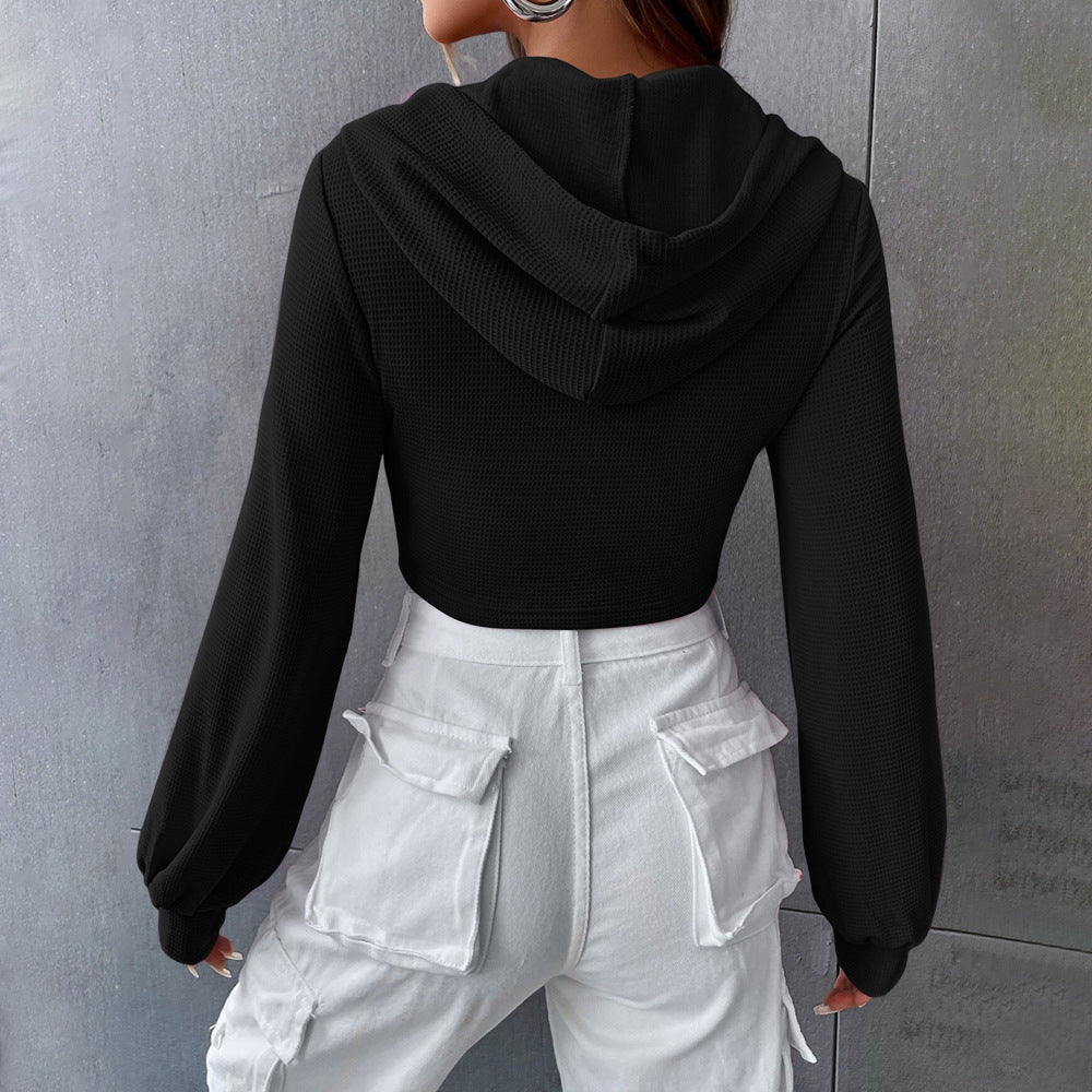 Black textured long-sleeved cropped hoodie with white cargo pants, stylish short faux fashion