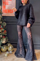 Woman in casual loose lace two piece set with black bell-bottom pants and fuzzy sweater