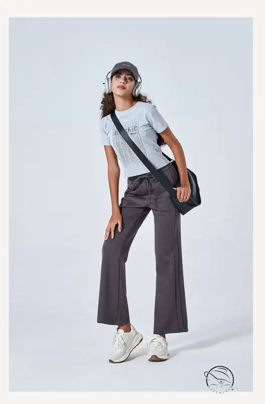 Woman in summer air layer cotton t-shirt, wide-leg yoga pants, sneakers, crossbody bag