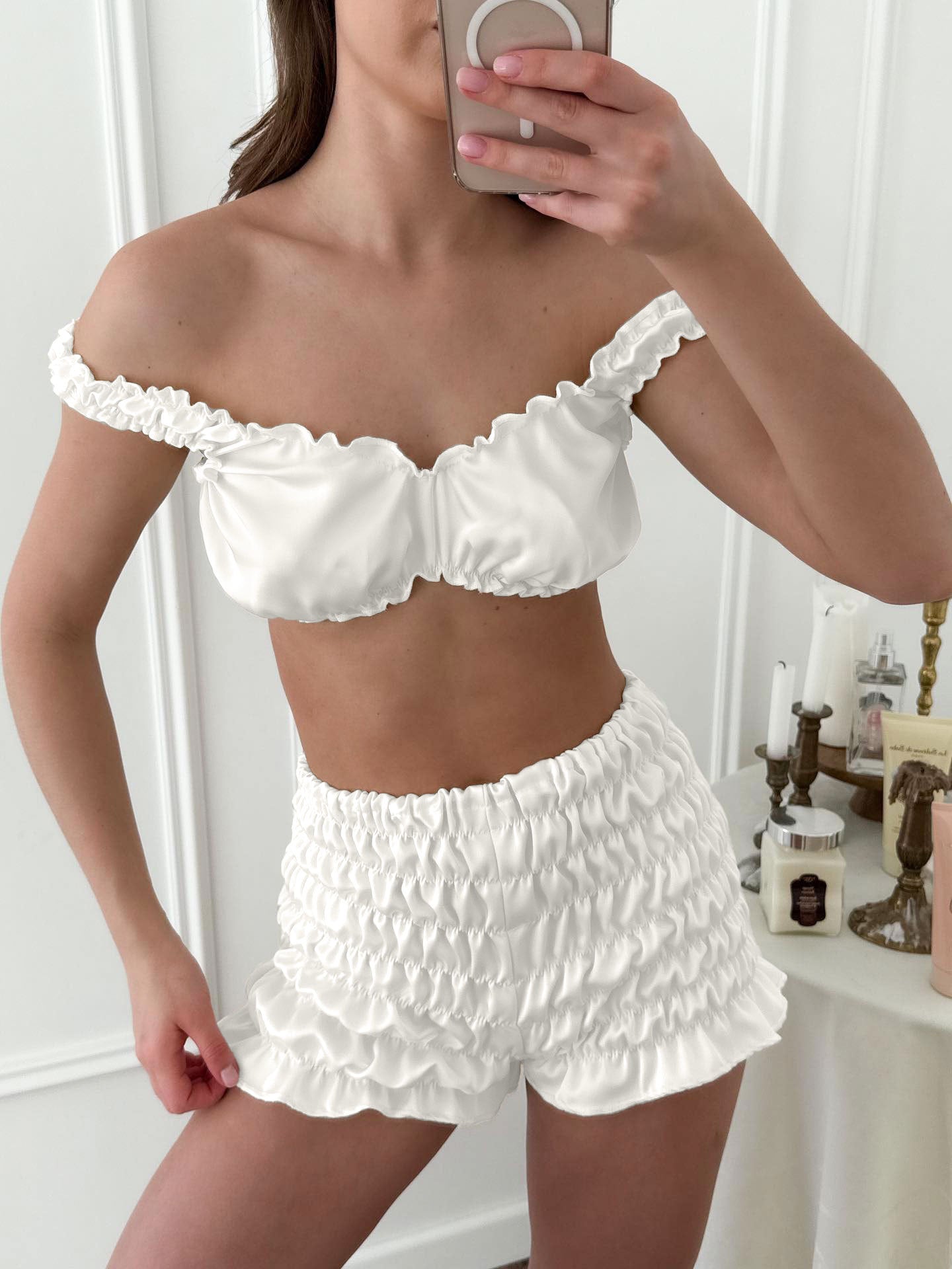White ruffled off-shoulder pleated satin crop top and shorts set with lace trim