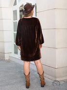 Woman in brown velvet mini dress and cowboy boots, loose slimming casual style