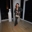 Woman in black pantsuit with gold purse in casual professional pants two piece set