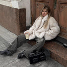Fashionable faux fur coat with black leather satchel