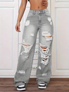 Gray distressed high-waisted langry jeans with white stitching and black sneakers
