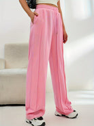 Pink wide leg track pants featuring side stripes and an elastic waistband for casual fashion