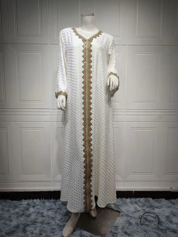 White and gold embroidered langry fashion dress on mannequin