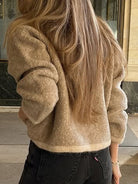 Golden faux fur shacket with regular sleeve, black jeans, gold bracelet