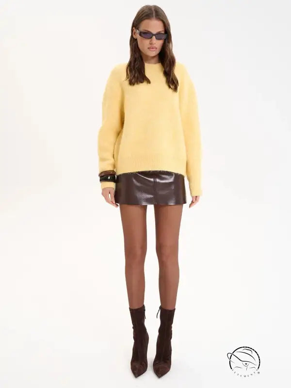 Winter loose long wool alpaca sweater in mustard yellow with black sunglasses and brown leather skirt
