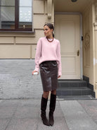 Winter loose long wool alpaca sweater with pink body, black collar, leather skirt, knee-high boots