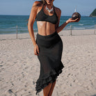 Black knitted two-piece beachwear set featuring crop top and ruffled skirt for stylish fashion