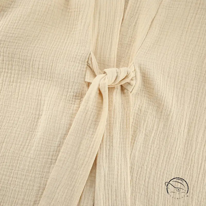 Close-up of beige textured winter pure cotton pajamas fabric with tie closure