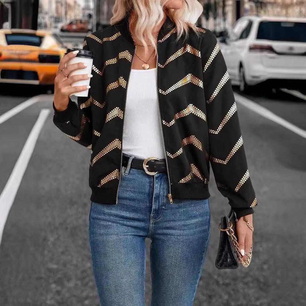 Woman wearing a black and gold chevron bomber jacket, showcasing trendy autumn fashion ملابس