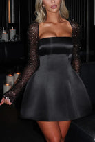 Black satin mini dress with beaded sleeves, perfect for casual meetings in fashion