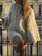 Oversized long sleeve cable knit sweater with high neck and orange shorts