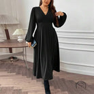 Woman modeling gorgeous large swing dress in black midi V-neck style