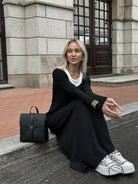 Fashion langry black knit maxi vest dress with white sneakers and black backpack
